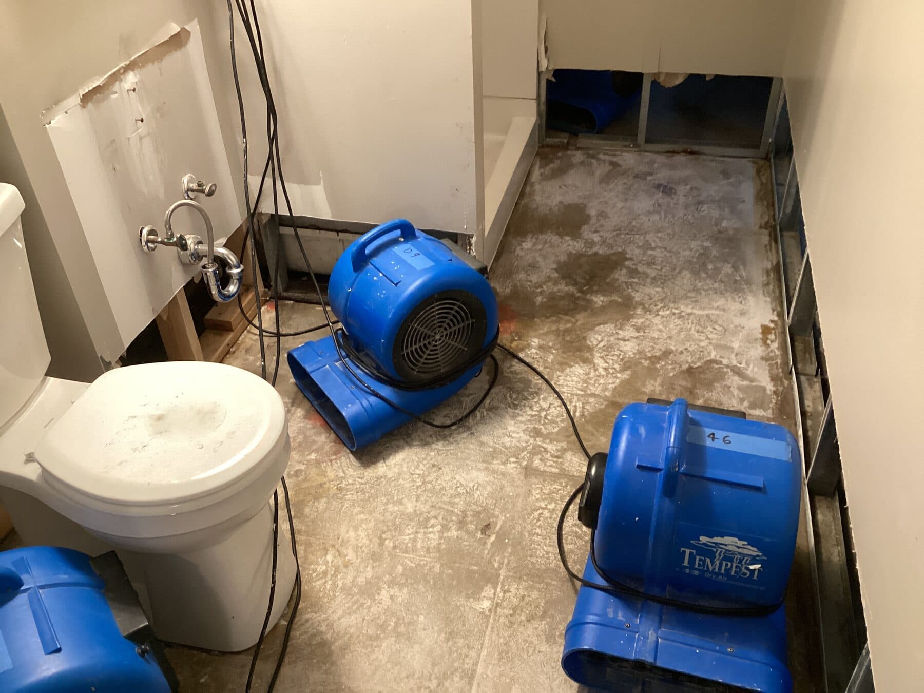 Air movers drying an unfinished bathroom during reconstruction